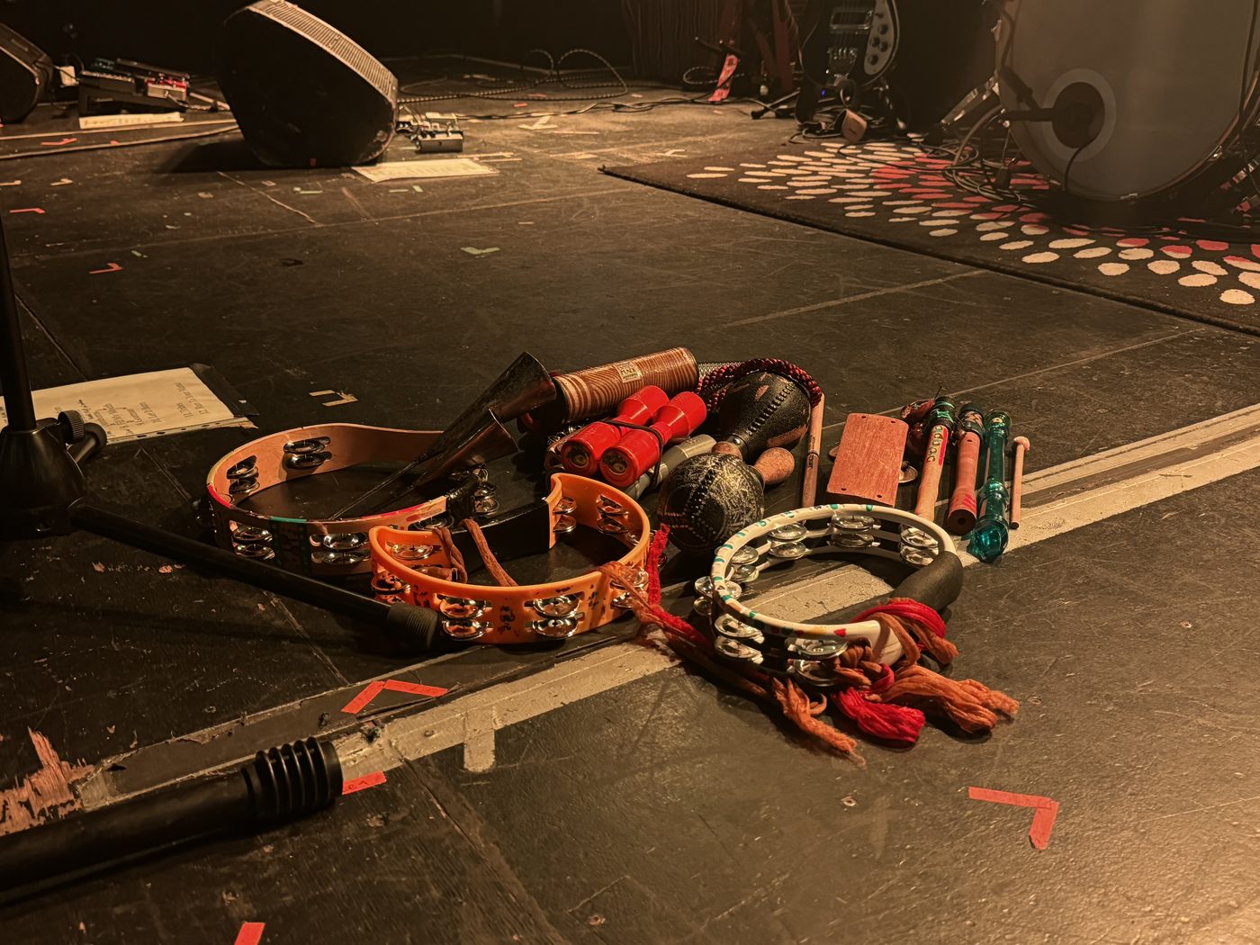 Tambourines, cowbells, and shakers lined up at the edge of the stage